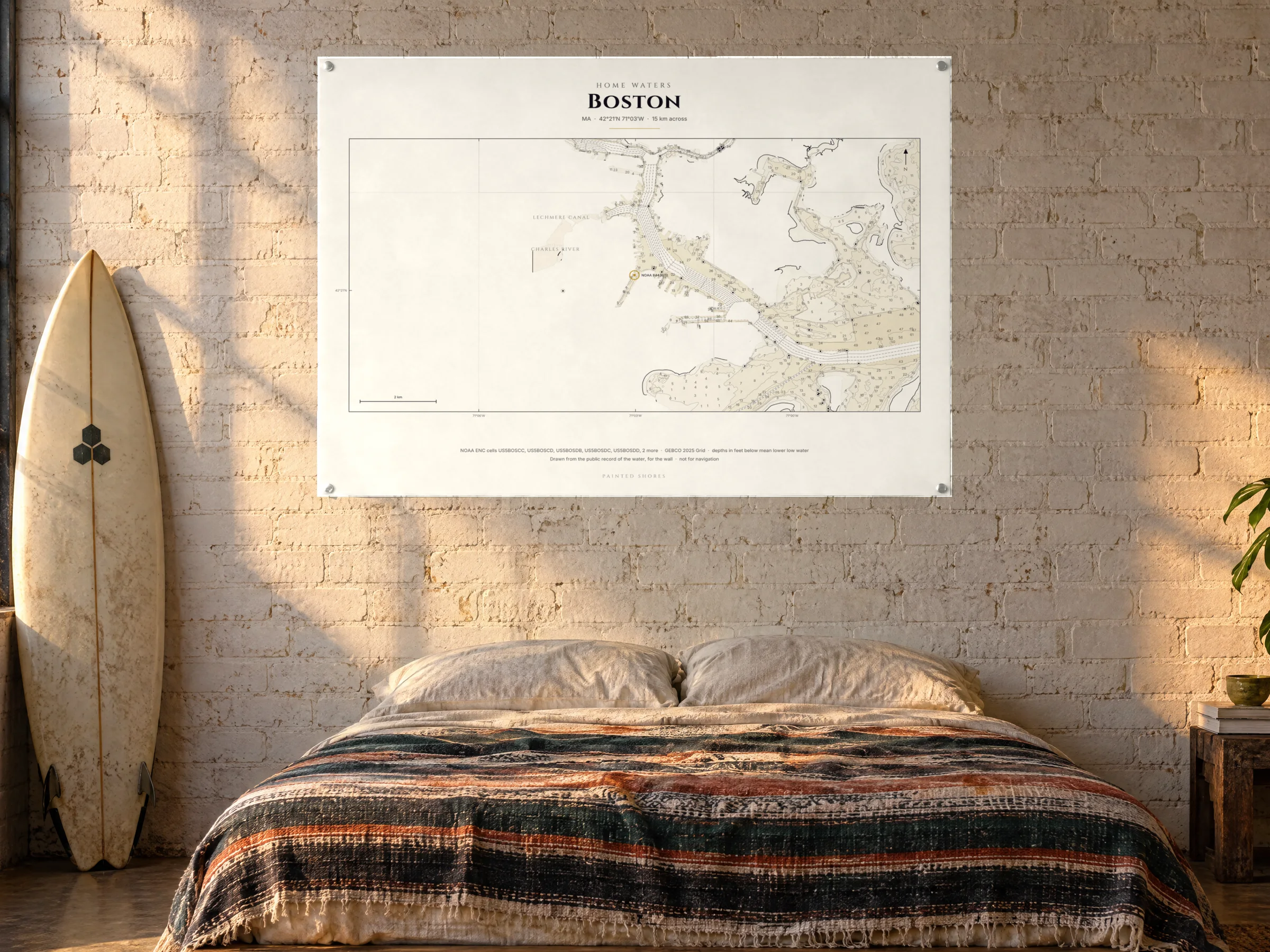 A wide horizontal home-waters chart pinned above a platform bed with a striped blanket, a shortboard under the window of a surfer's loft
